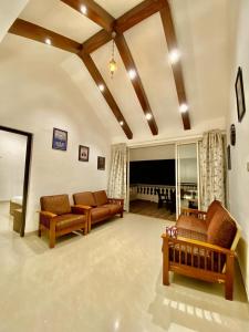 un grand salon avec des canapés et une grande fenêtre dans l'établissement West Valley Villa 4Bhk Lonavala, à Lonavala