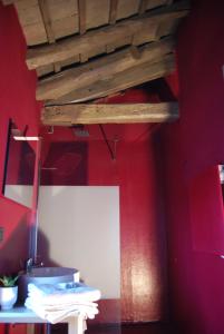 a room with red walls and a wooden ceiling at b & b Alle 3 palme in San Giórgio di Nogaro