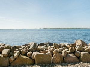 um monte de pedras na costa de um corpo de água em 4 person holiday home in Gr sten em Grasten