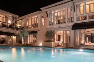a large building with a swimming pool at night at B House Samui in Bangrak Beach