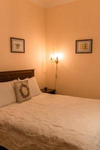 a bedroom with a bed with white sheets and a lamp at Ekaterinoslav in Dnipro