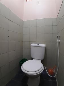 a bathroom with a white toilet in a room at OYO 671 Natua's Cabin in Puerto Princesa City