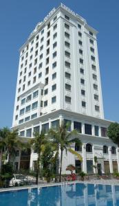 a large white building with a pool in front of it at Kim Bao Hotel in Hải Dương