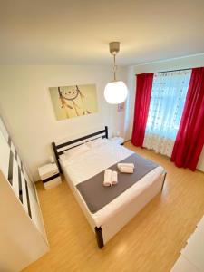 1 dormitorio con 1 cama con 2 toallas en Alpha Apartment en Brasov