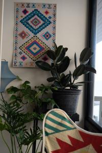 a room with plants and a chair and a quilt at B House Samui in Bang Rak Beach