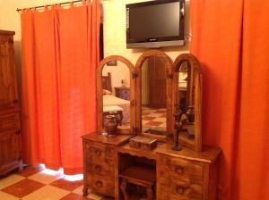a room with a television and a dresser with a mirror at Hotel Julio in Trujillo