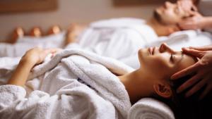 a woman laying on a bed under a towel at Pullman Sharjah in Sharjah