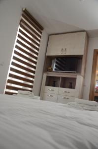 una camera da letto con un letto bianco e una finestra di Apartman Kalina Suncani Breg a Kopaonik