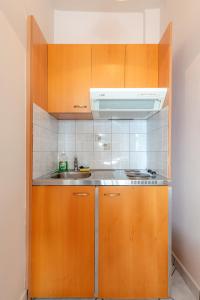 a kitchen with wooden cabinets and a sink at Naftilos Studios in Lourdata