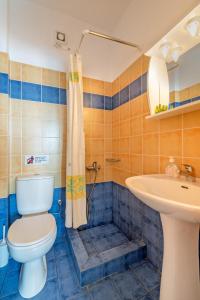 a bathroom with a toilet and a sink at Naftilos Studios in Lourdata +30 photos