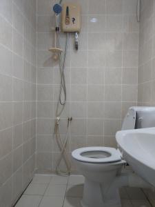 a bathroom with a shower and a toilet and a sink at ENE Inn in Kota Bharu