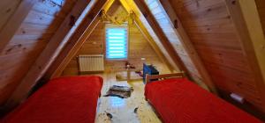 an attic room with two beds and a window at Lodge Ljubiska Previja in Ljubiš