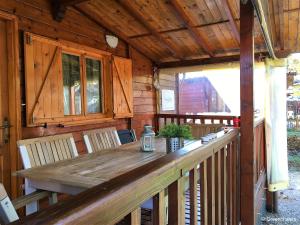 une terrasse en bois avec une table et des chaises en bois dans l'établissement Italy Lago Di Lugano Porlezza, à Porlezza