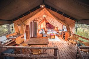 una sala de estar de una tienda con mesa y sillas en Domaine de la Vitarelle Glamping, en Villanière