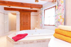 La salle de bains blanche est pourvue d'une baignoire et d'une fenêtre. dans l'établissement Ferienresidenz Florian, à St. Johann in Tirol