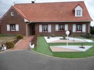 une maison avec un toit rouge et une cour d'herbe dans l'établissement Studio Bourgois, à Berck-sur-Mer