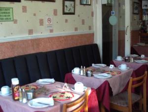two tables in a restaurant with pink table cloths at Jollies Hotel in Blackpool