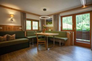 a living room with a table and a couch at Haus Dabaklamm in Kals am Großglockner