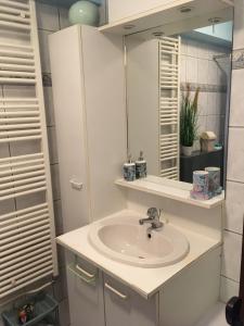 a bathroom with a sink and a mirror at Knus appartement met zijdelings zeezicht in Ostend