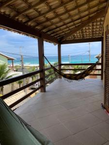 uma rede de descanso num alpendre com vista para a praia em Casa de frente pro mar em Arraial do Cabo em Arraial do Cabo