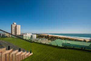 a view of a beach and a building and the ocean at Paxton Luxury Apartments self-catering in Port Elizabeth