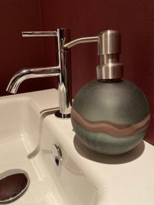 a soap dispenser sitting on top of a bathroom sink at Nova Zembla in Mechelen