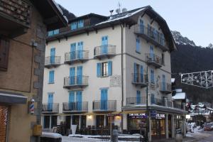 a large white building with balconies on a street at Appartement Le Savoisien in Chamonix