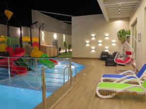 einen Pool mit Rutschen und Stühlen neben einem Pool in der Unterkunft استراحة منتجع بالى in Dschidda