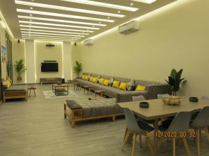 - un salon avec des canapés, des tables et une télévision dans l'établissement استراحة منتجع بالى, à Djeddah