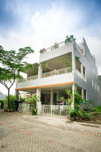 a large white building with a balcony on it at INNI Homestay in Malang