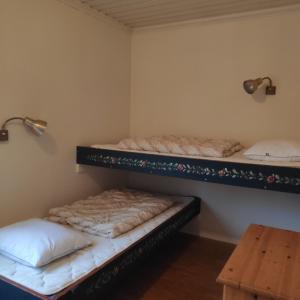 two bunk beds in a room with a table at Ekesberget Stugby Stuga 8 in Ekshärad
