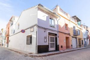 un bâtiment blanc sur le côté d'une rue dans l'établissement Boutique House Alzira, à Alzira