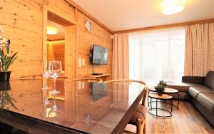 Alpin & See Resort - Pinzgau Holidays في زيل أم سي: غرفة معيشة مع طاولة وكراسي زجاجية
