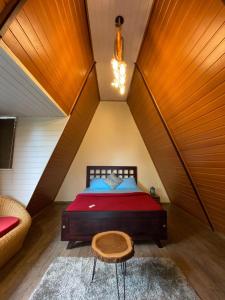 a bedroom with a red bed in a attic at Wild root stay- Orchid Chalet in Vythiri