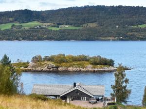 una casa en una isla en un gran cuerpo de agua en 8 person holiday home in TORVIKBUKT, en Torvikbukt