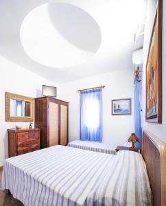 - une chambre avec 2 lits et une commode dans l'établissement Residence del Sole, à Lampedusa