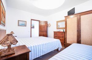 ランペドゥーザにあるレジデンス デル ソーレのベッド2台とドレッサーが備わるホテルルームです。