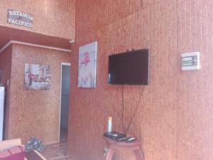 a living room with a tv on a wall at Estancia Pacífico in Punta de Choros +3 photos
