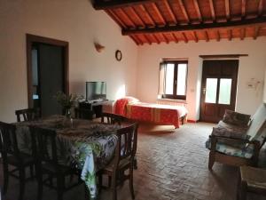 sala de estar con cama, mesa y sillas en Agriturismo Il Cornalino, en Castel Viscardo