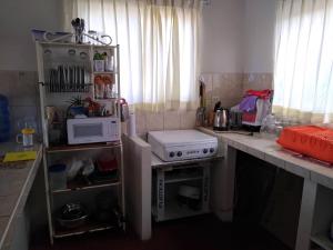 a small kitchen with a stove and a microwave at Bonanza Beach House Zorritos in Bocapán