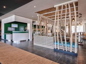 a restaurant with a bar with trees inside of it at ibis Styles Arcachon Gujan Mestras in Gujan-Mestras