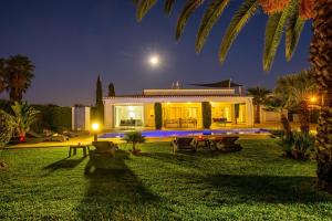 a villa with a garden at night at Villa Koster by Algarve Vacation in Carvoeiro