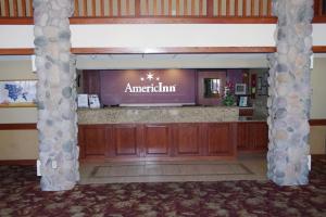 an entrance to an emergency room with two columns at AmericInn by Wyndham Grimes in Grimes