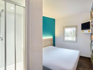 トリニャックにあるhotelF1 Saint Nazaire La Bauleのベッドと窓が備わる小さな客室です。