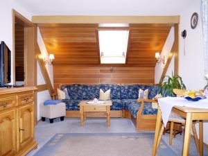 a living room with a blue couch and a table at Gästehaus Alfred Klais in Krün