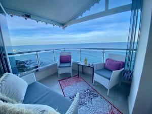 ein Balkon mit Stühlen und einem Tisch und das Meer in der Unterkunft Trabzon Seaside in Trabzon