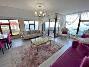 ein Wohnzimmer mit lilafarbenen Möbeln und einem Kronleuchter in der Unterkunft Trabzon Seaside in Trabzon