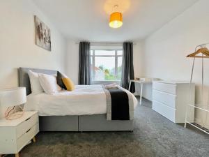 um quarto com uma cama, uma secretária e uma janela em Kingsbridge Apartment em Glasgow