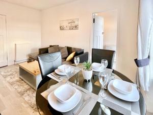 a dining room with a table and a couch at Kingsbridge Apartment in Glasgow