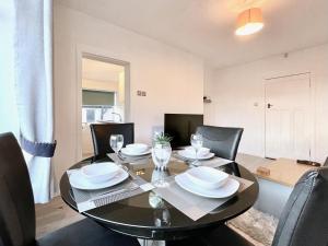 a dining room with a black table and chairs at Kingsbridge Apartment in Glasgow